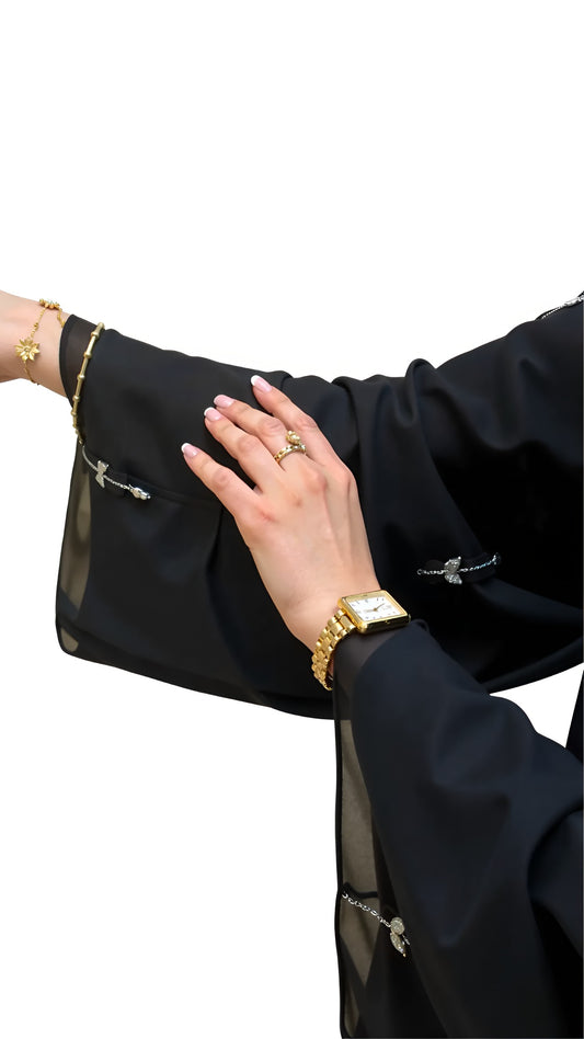 Women wearing a black outfit with gold jewelry on a white background