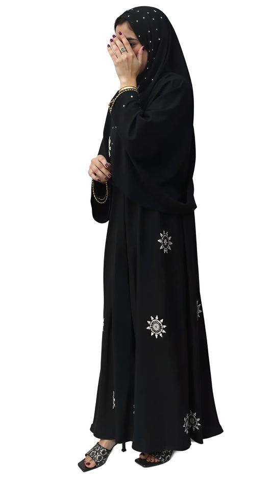 Women wearing a black abaya with white patterns on a white background