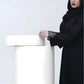 Woman wearing a black abaya with fishnet sleeves against a white background