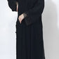 Person wearing a black abaya on a white background