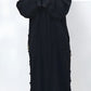 Person wearing a black abaya with floral details on a white background